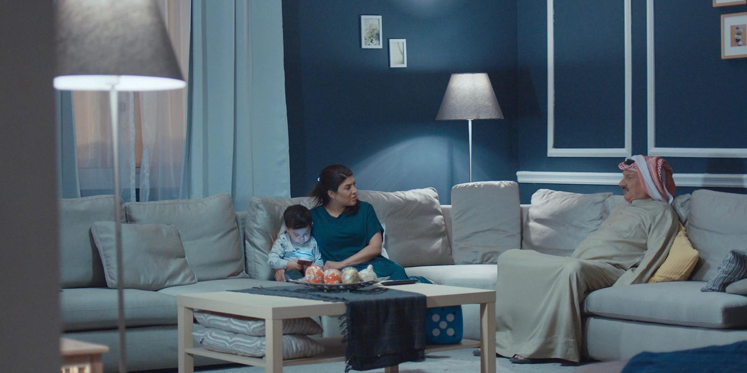 A full shot of a person standing in front of a beautiful mountainous landscape.